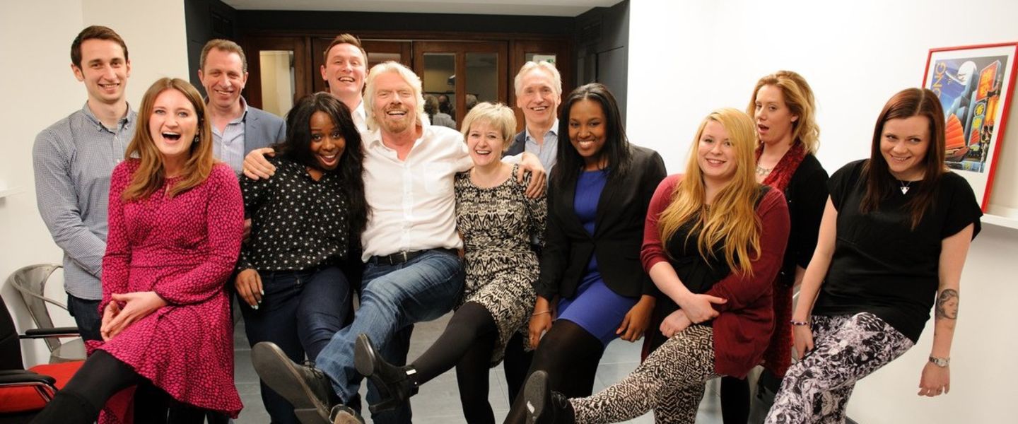 Richard Branson with Virgin team members, posing for the photo