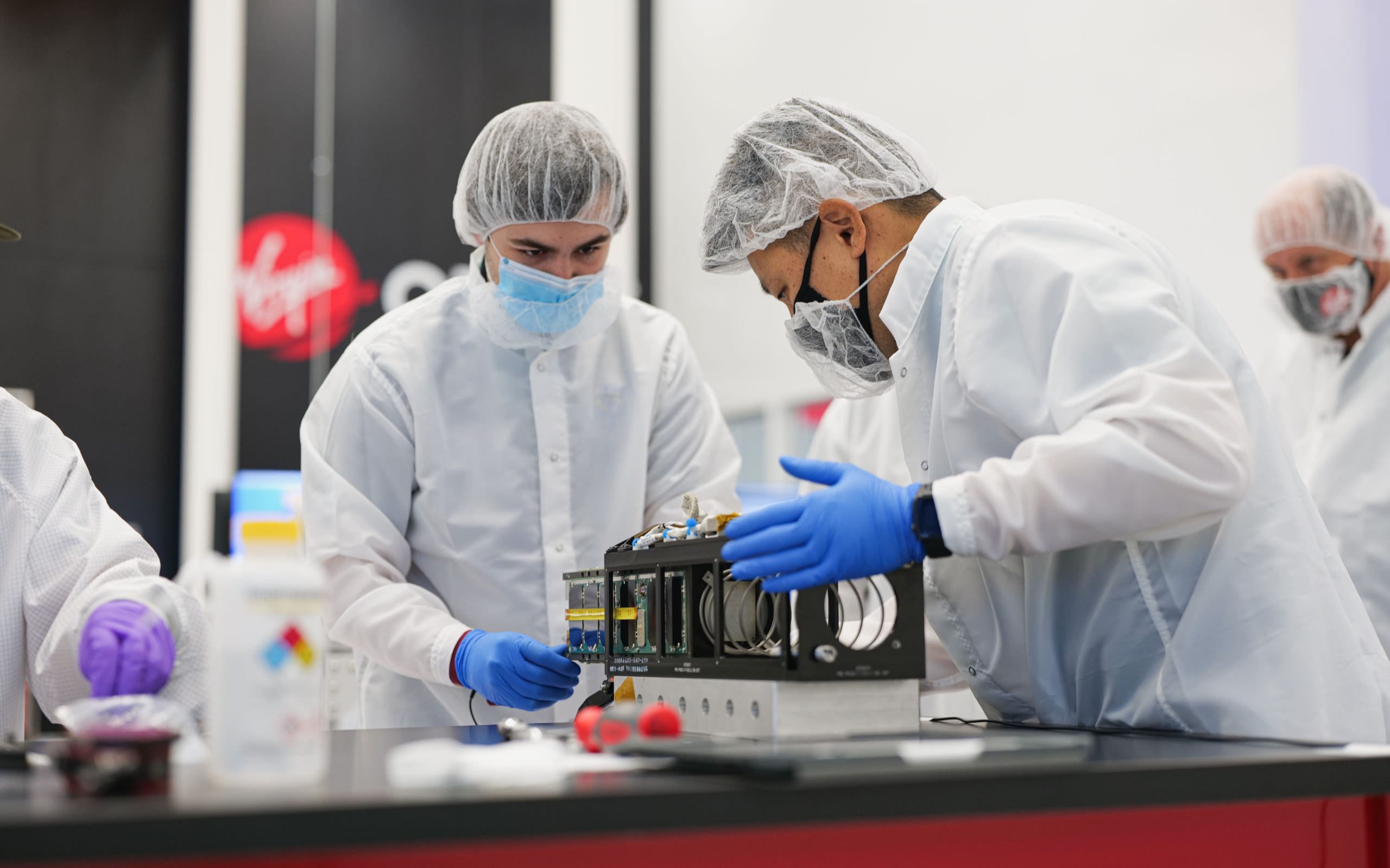 Ahead of Virgin Orbit's Launch Demo 2 mission, the MiTEE-1 spacecraft is loaded into a dispenser by Cade Wright, an engineering student at the University of Michigan, and Xtenti CEO Dan Lim.