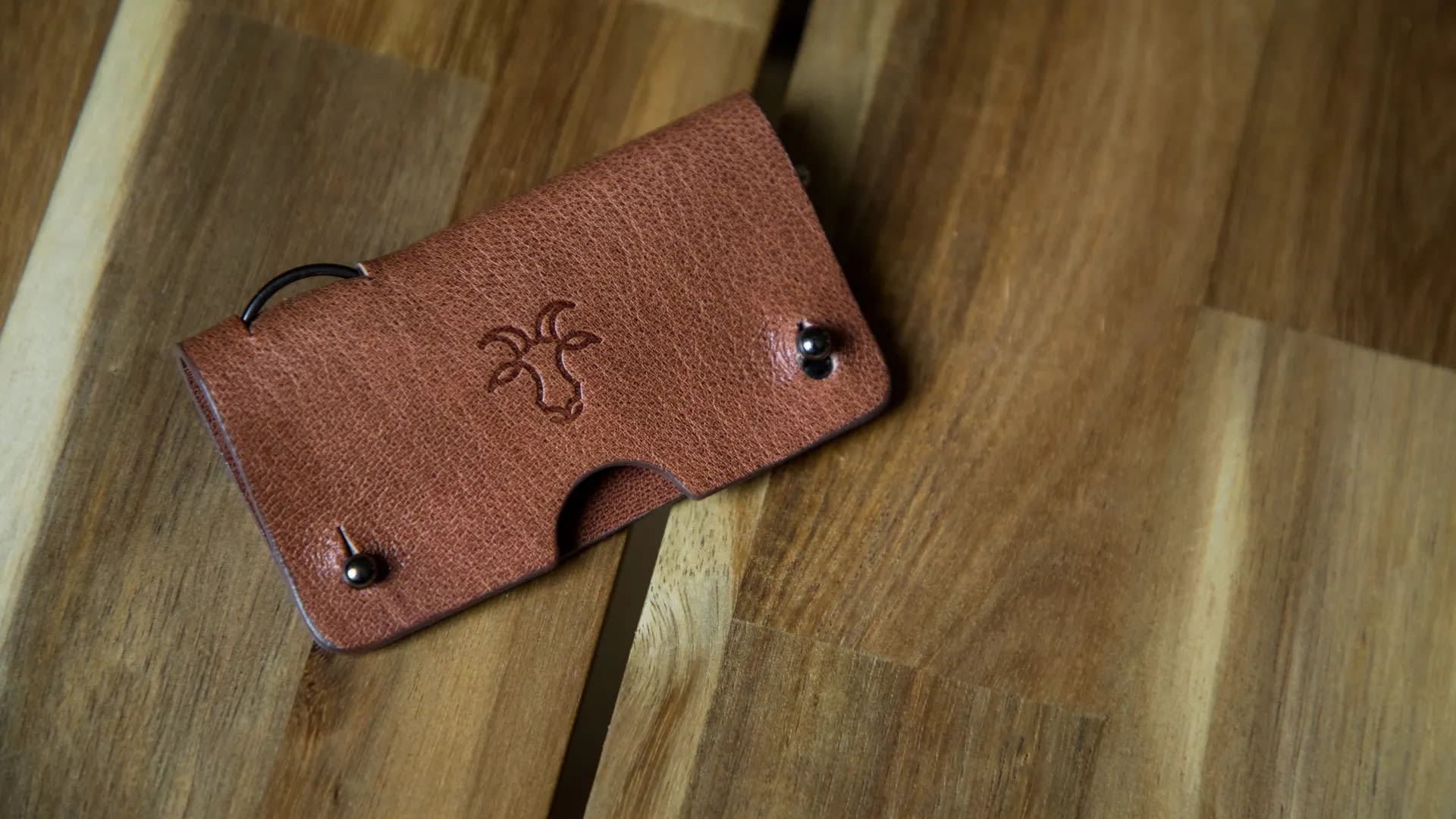 A brown leather key wrap on a wooden background