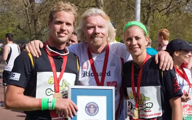 Saam Branson, Richard Branson and Holly Branson smile with their medals at the London Marathon