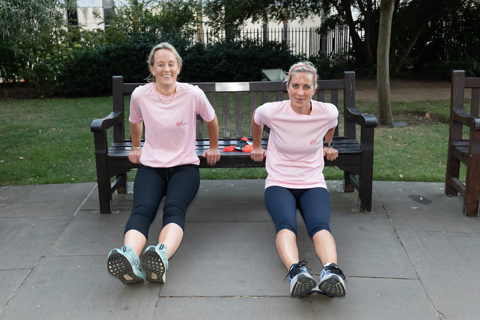 Holly Branson exercises on a park bench with another woman