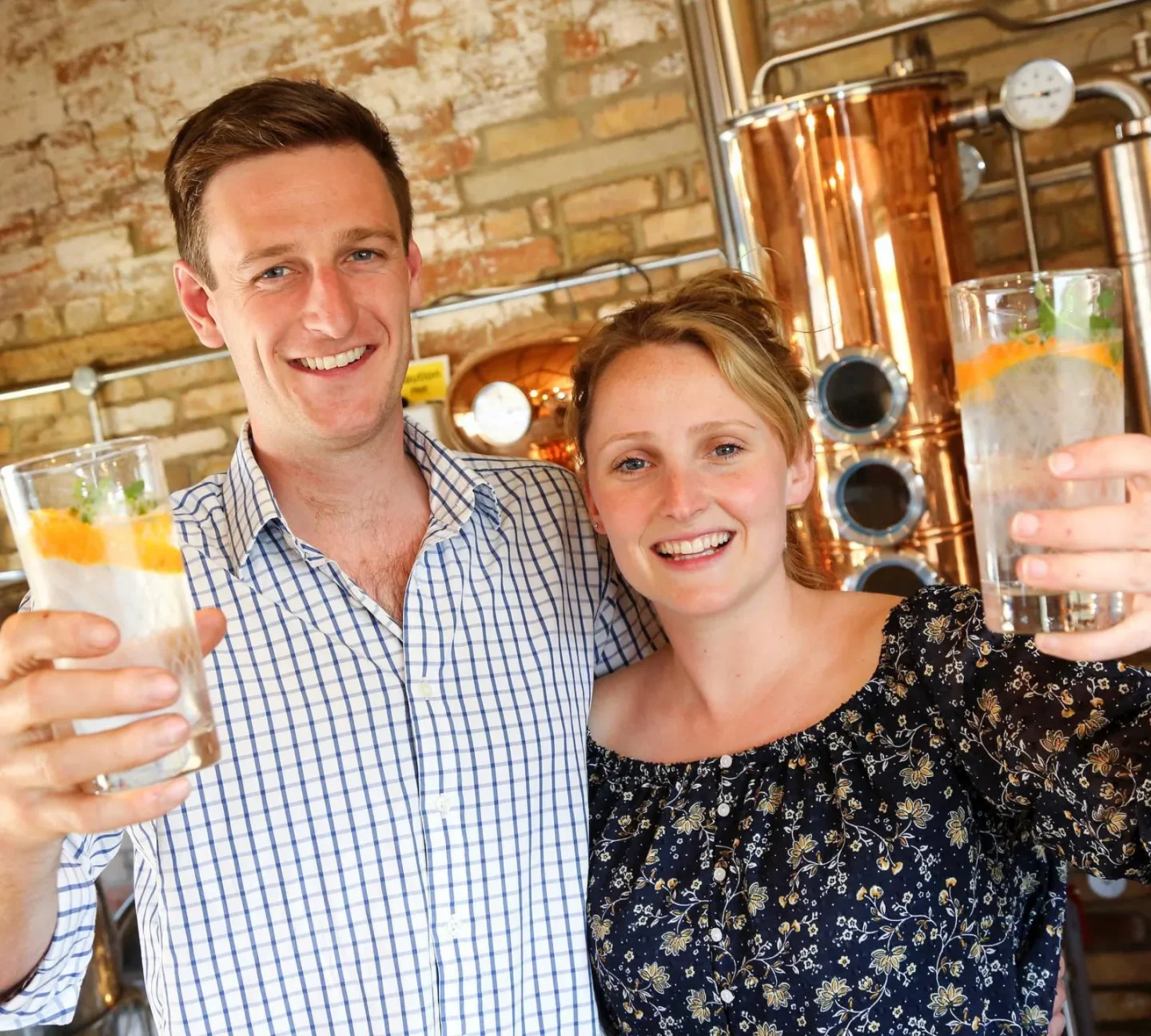 Founders of Roundwood Gin smile and hold up their glasses of gin