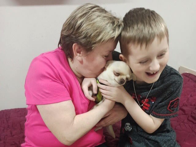 Yasia and Dima holding their puppy after fleeing Ukraine with the help of Tabletochki