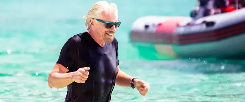 Richard Branson in a pool wearing glasses and a wet suit