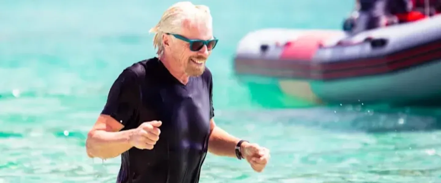 Richard Branson in a pool wearing glasses and a wet suit