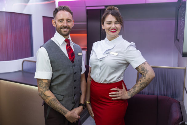 Two members of Virgin Atlantic crew showing off their tattoos