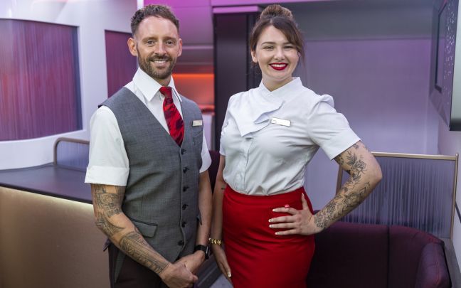 Two members of Virgin Atlantic crew showing off their tattoos