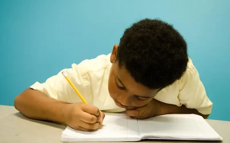 Young child writing in school book