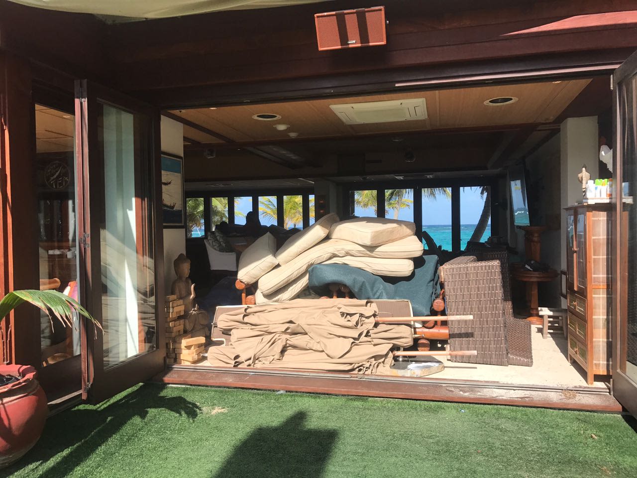 Outdoor furniture, cushions and parasols piled up inside the room