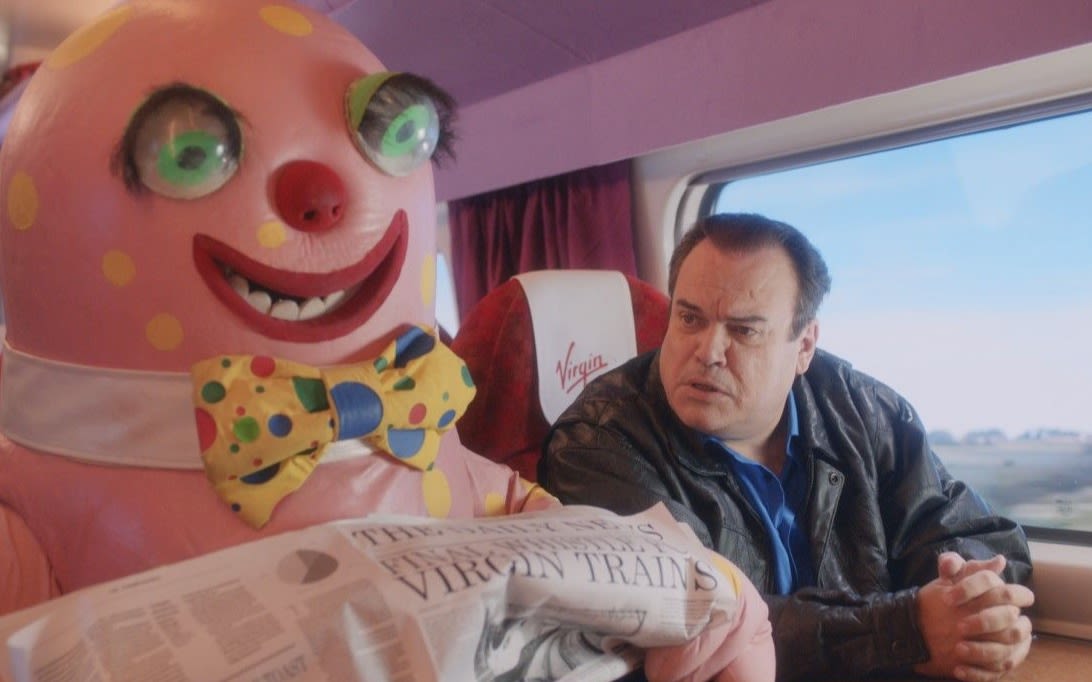 Blobby Barry reading the newspaper on a Virgin Trains train