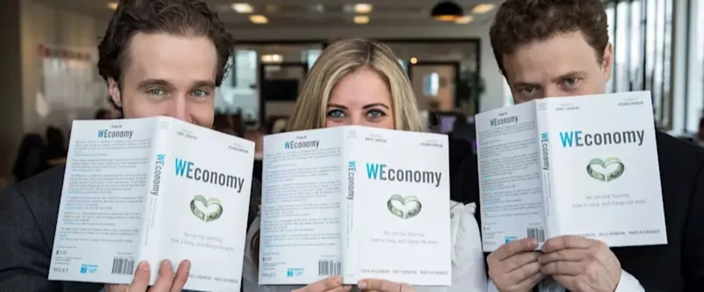 Holly Branson and two other people holding the WEconomy book