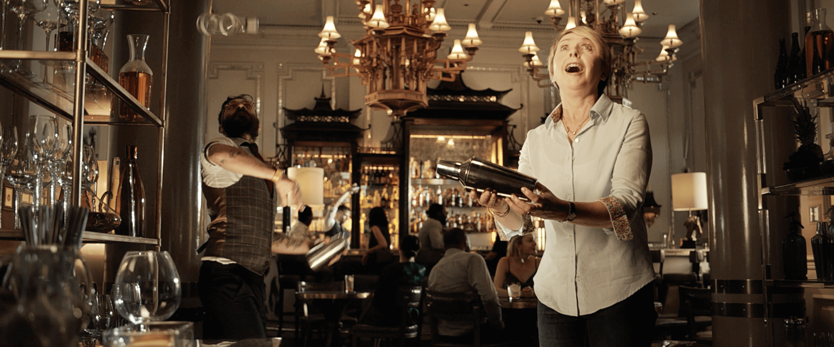 Woman in white shirt shaking a cocktail maker