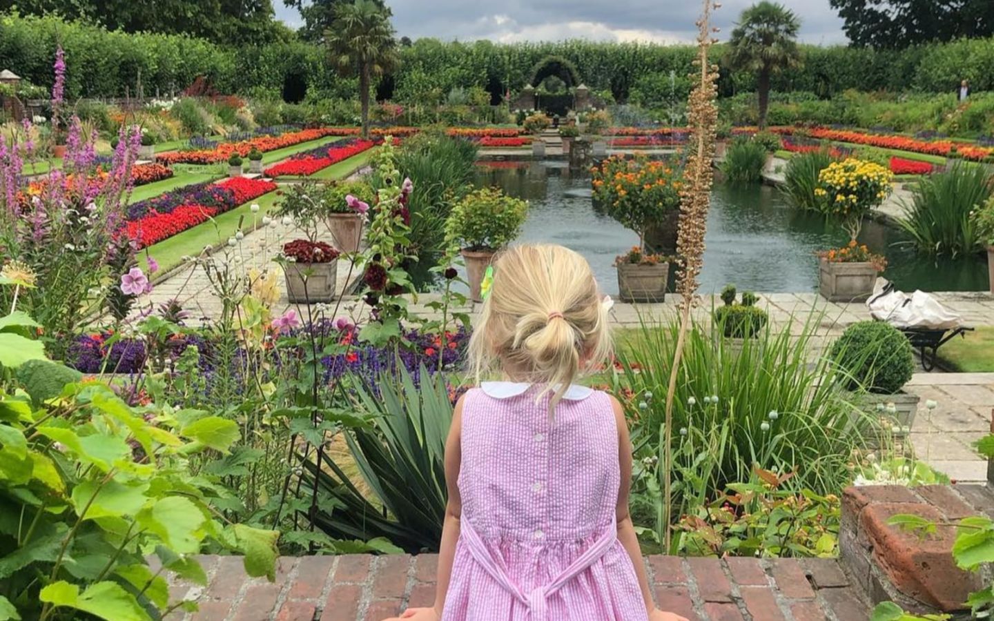 Holly Branson's daughter, Etta, overlooking a pond and landscaped gardens