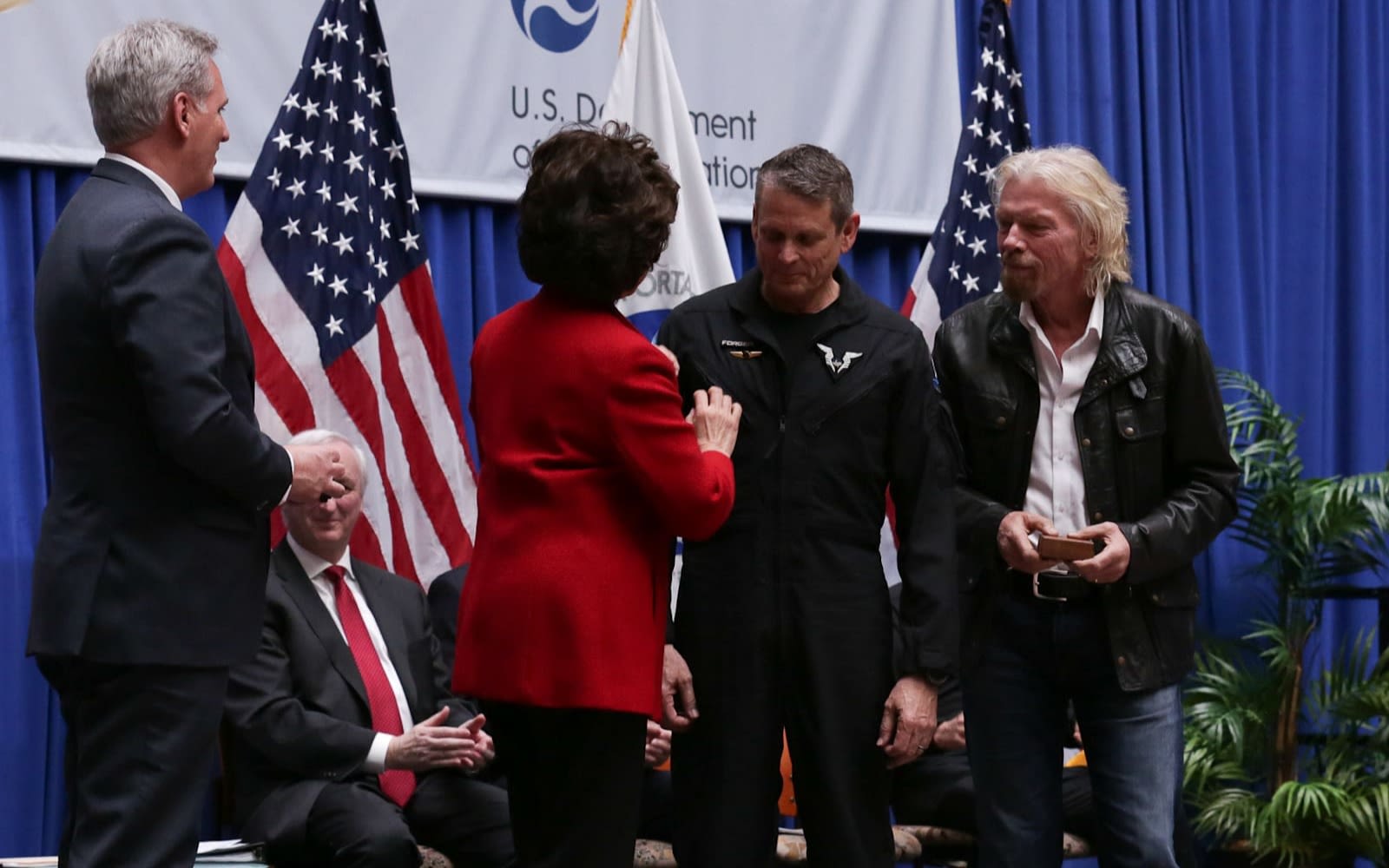 Mark 'Forger' Stucky receives his commercial astronaut wings from Elaine Chao as Richard Branson looks on
