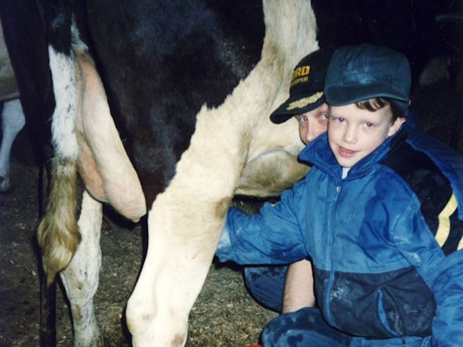 Until I was older, my dad did most of the milking. Here he is showing me how to wash the teats to keep the cow's udders clean. It would be an "udder" mess if they were dirty!