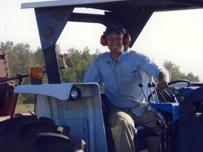 When I got older, I was able to drive the big tractors. Here I am round-baling, which is much more favorable than square. Note the hearing protection, tractors are loud.