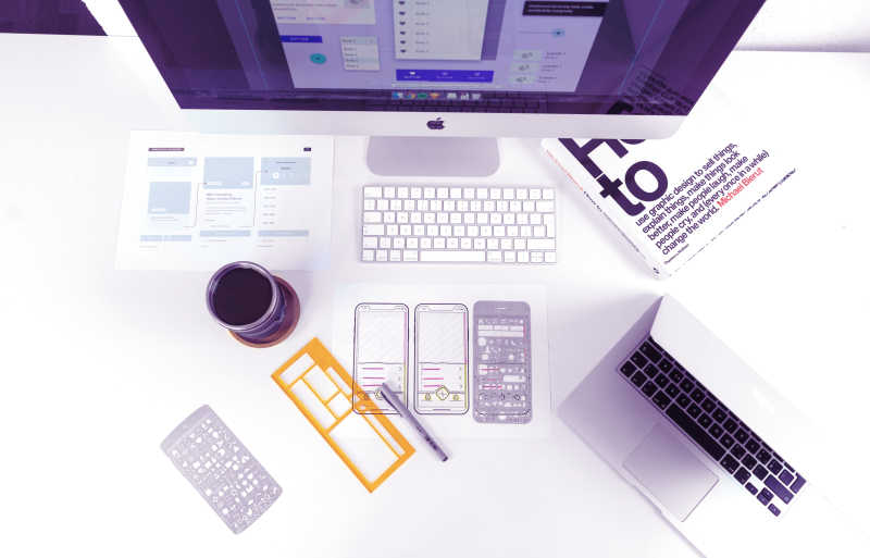 Illustration of top view of a white table with Mac screen, MacBook, magic keyboard, mug, book, pen and sketches of phones