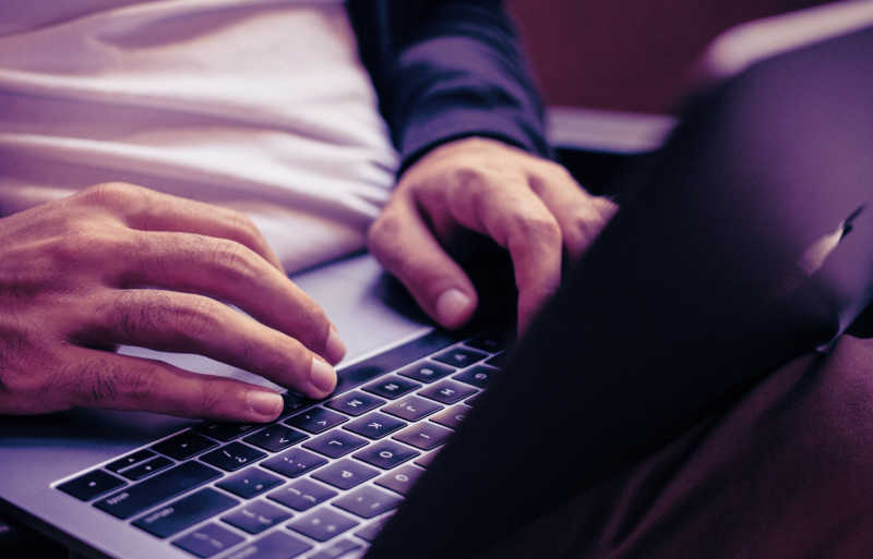 Close up image of a person typing on a computer