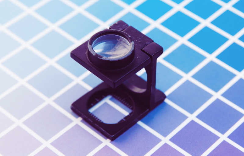 An illustration of a magnifying glass and a square patterned background