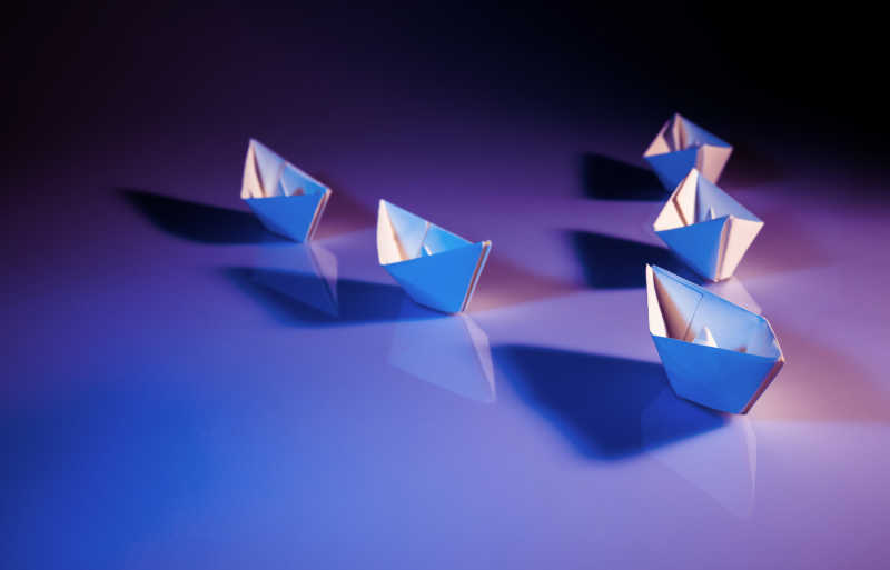  Illustration in blue and purple background with five white paper boats