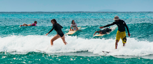 Cours de surf où l'on voit Yohann, le moniteur, donner des conseils aux élèves pour s'améliorer.