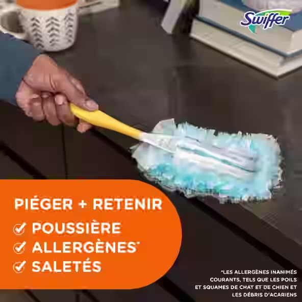 Personne utilisant un plumeau Swiffer pour nettoyer une surface sombre, mettant en évidence les capacités d'élimination de poussière et des allergènes