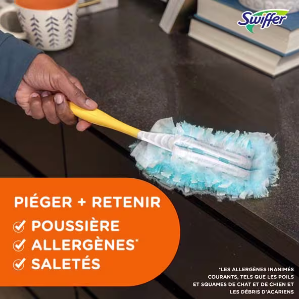 Personne utilisant un plumeau Swiffer pour nettoyer une surface sombre, mettant en évidence les capacités d'élimination de poussière et des allergènes