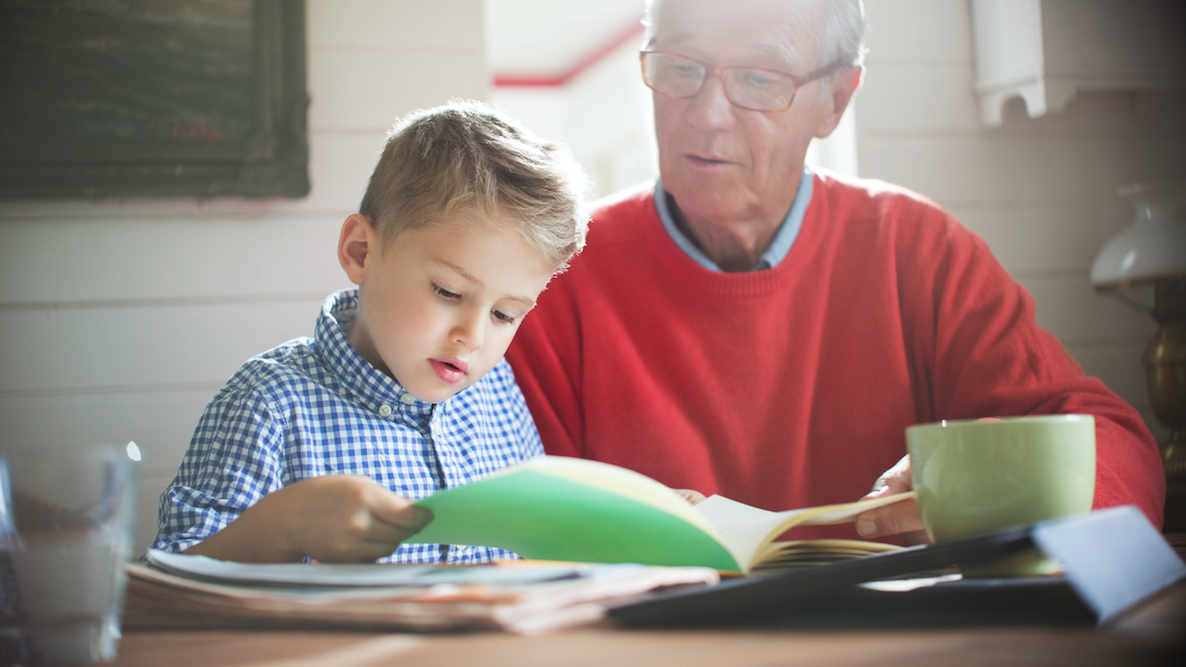 Older person reading a book with a young child