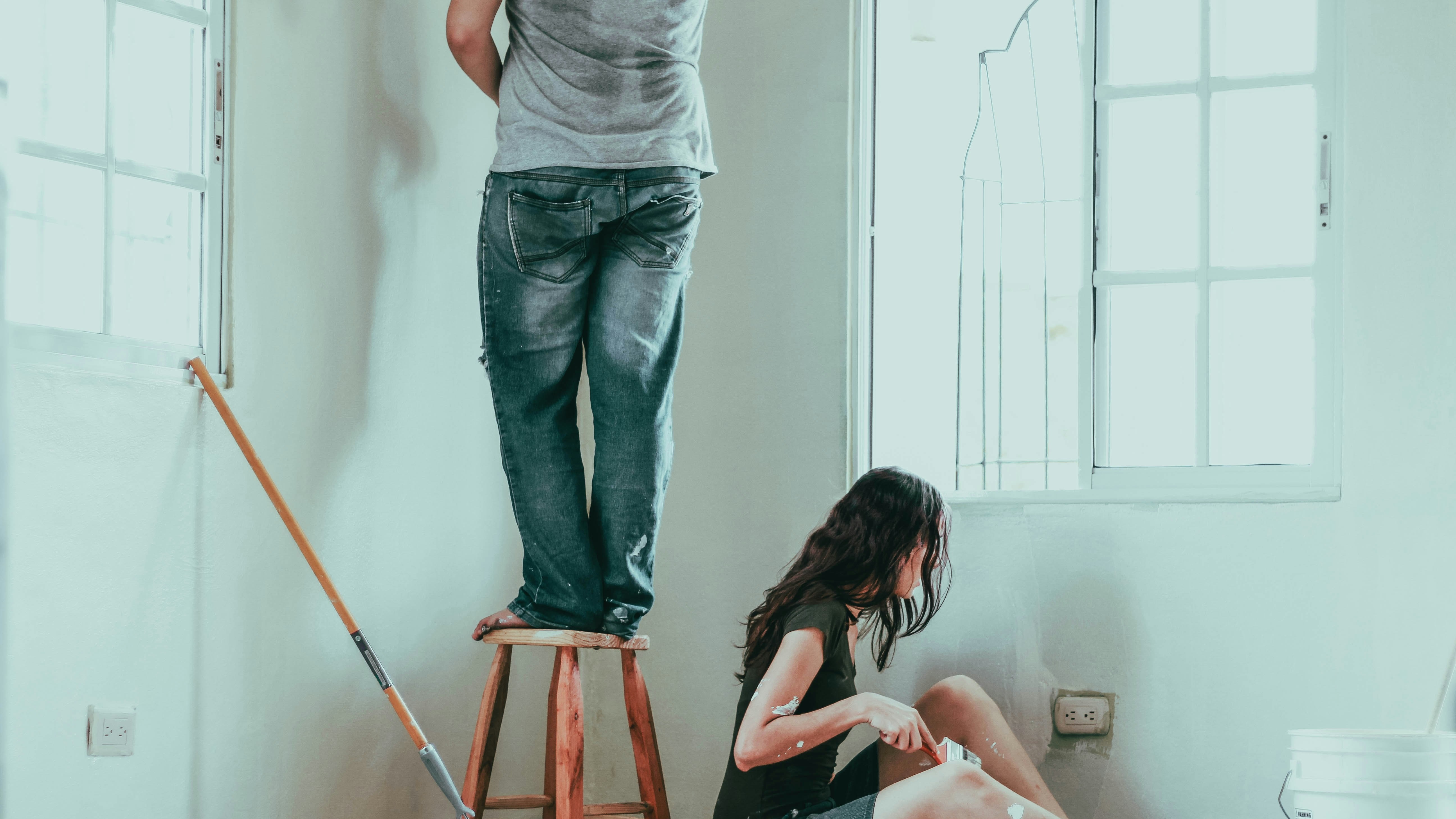 Two people painting a room