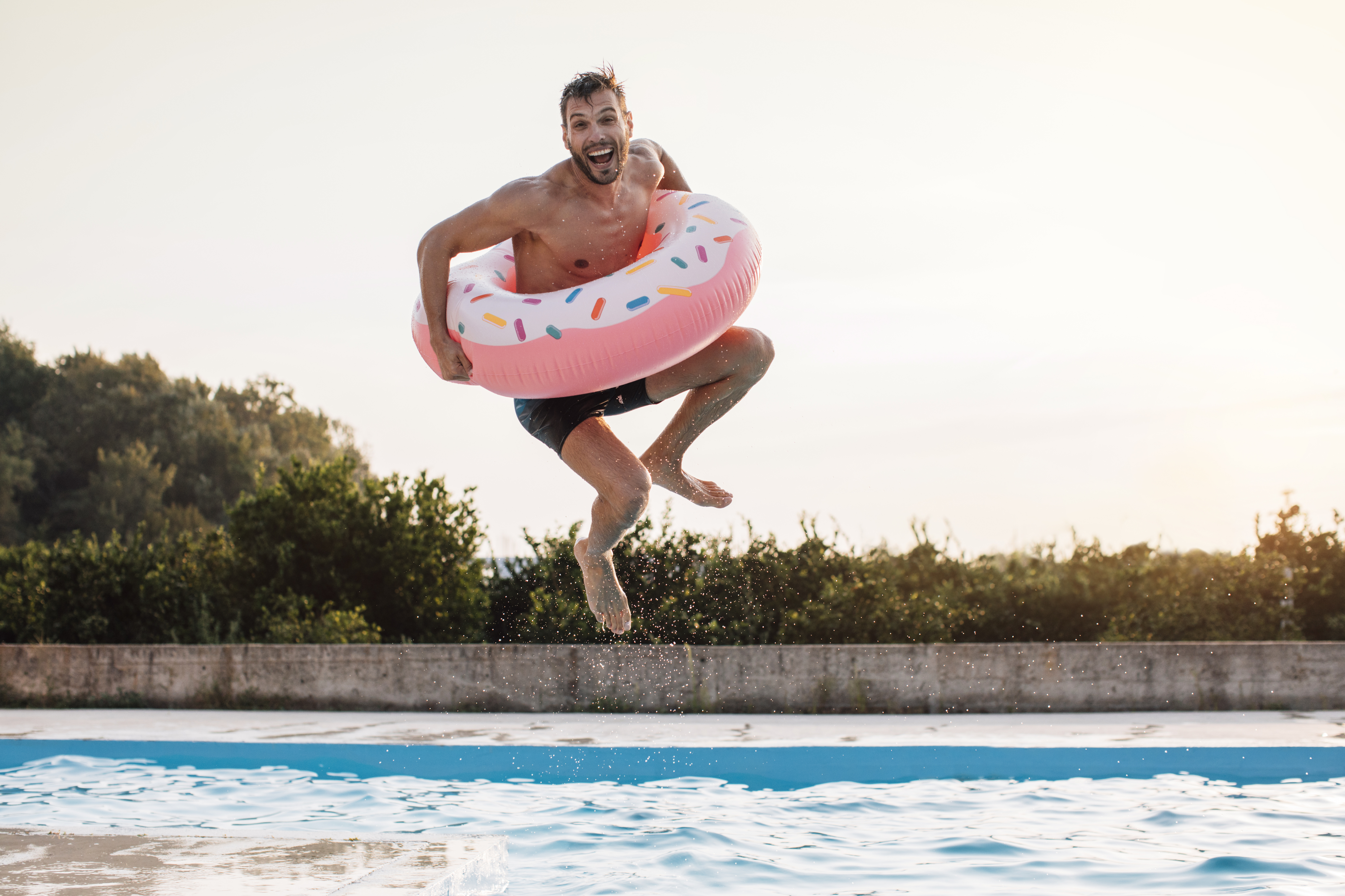Woman sat on an inflatable flamingo in a swimming pool