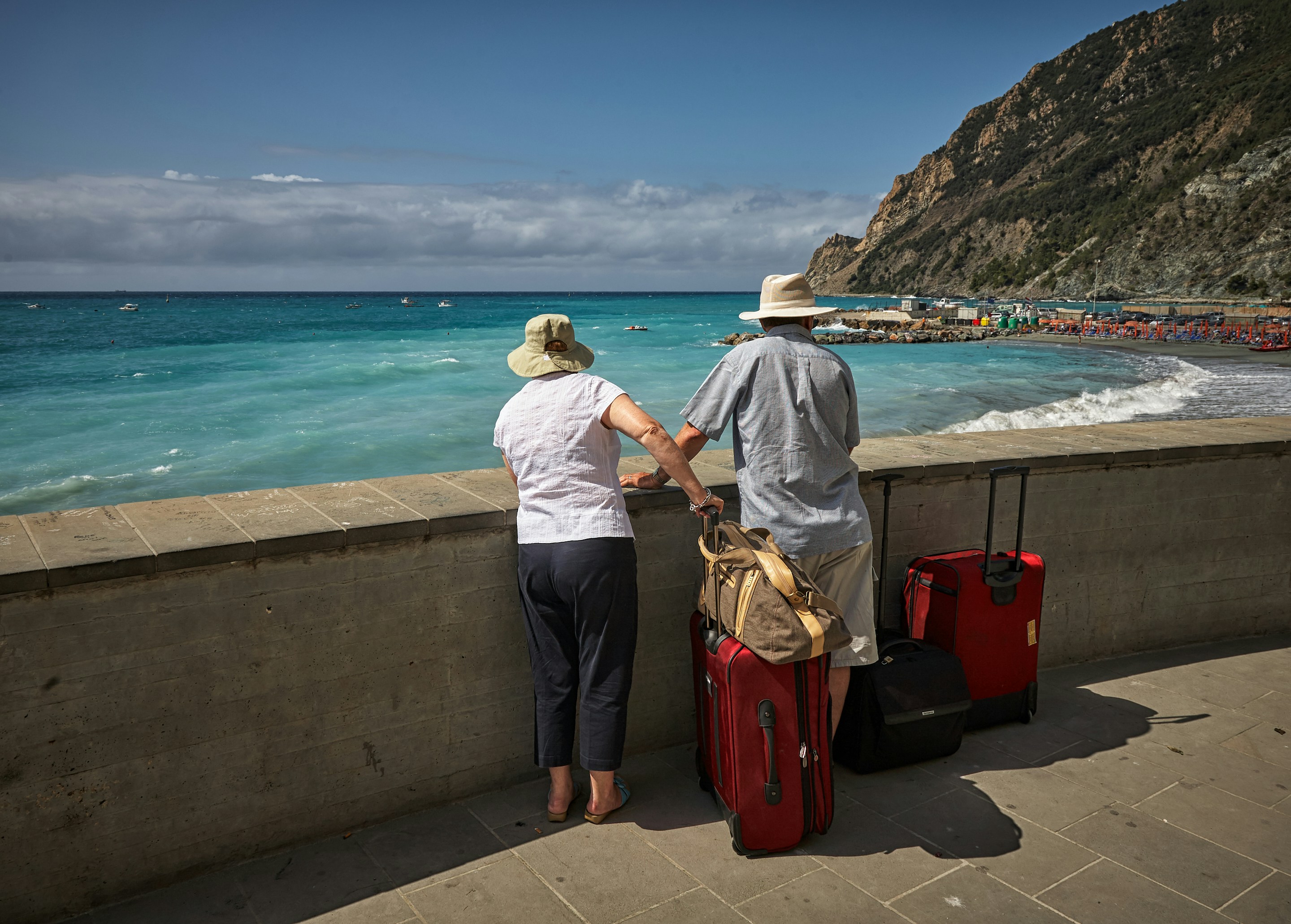 Couple with cases looking at the sea