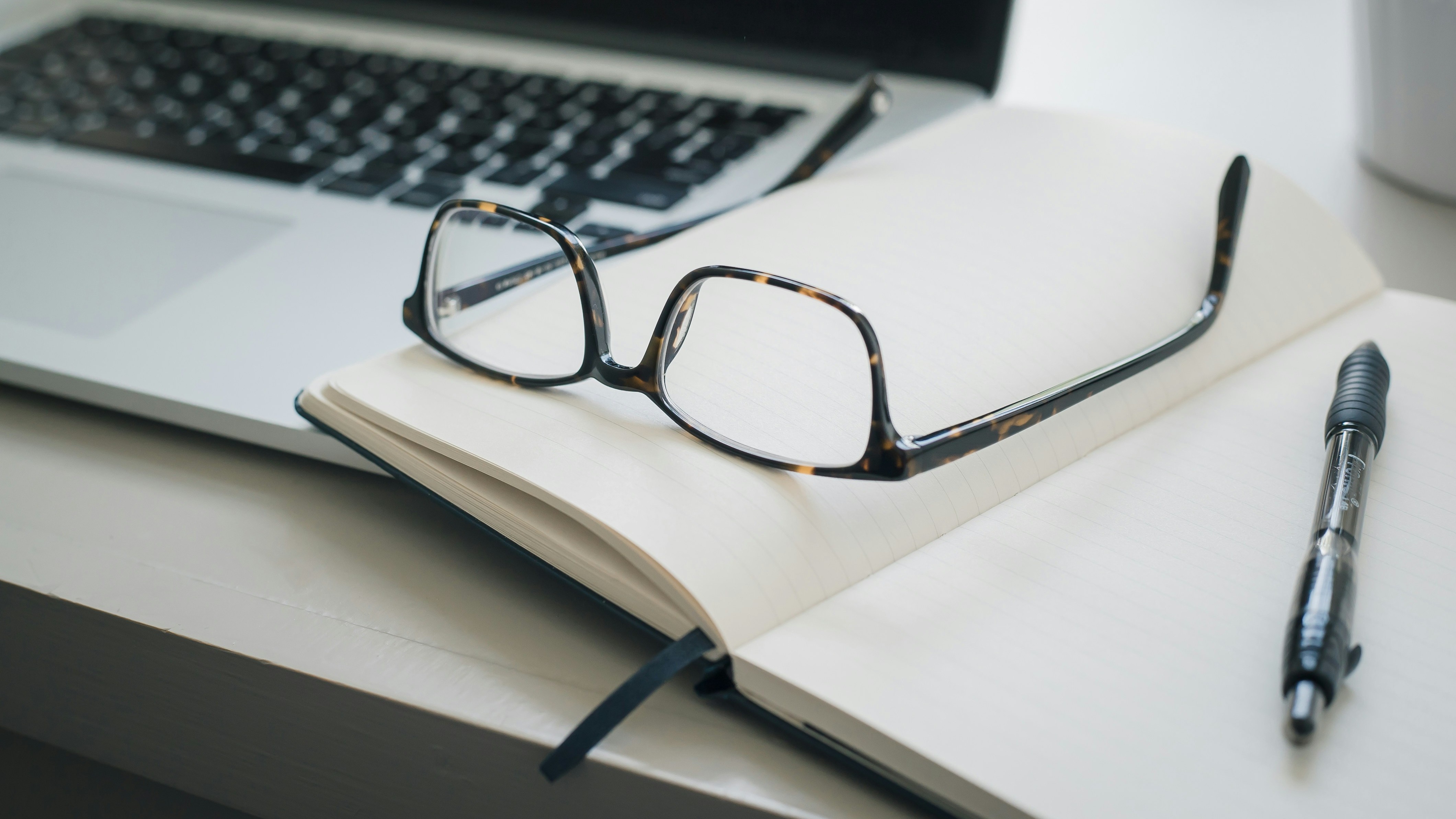 Glasses and pen on a notepad