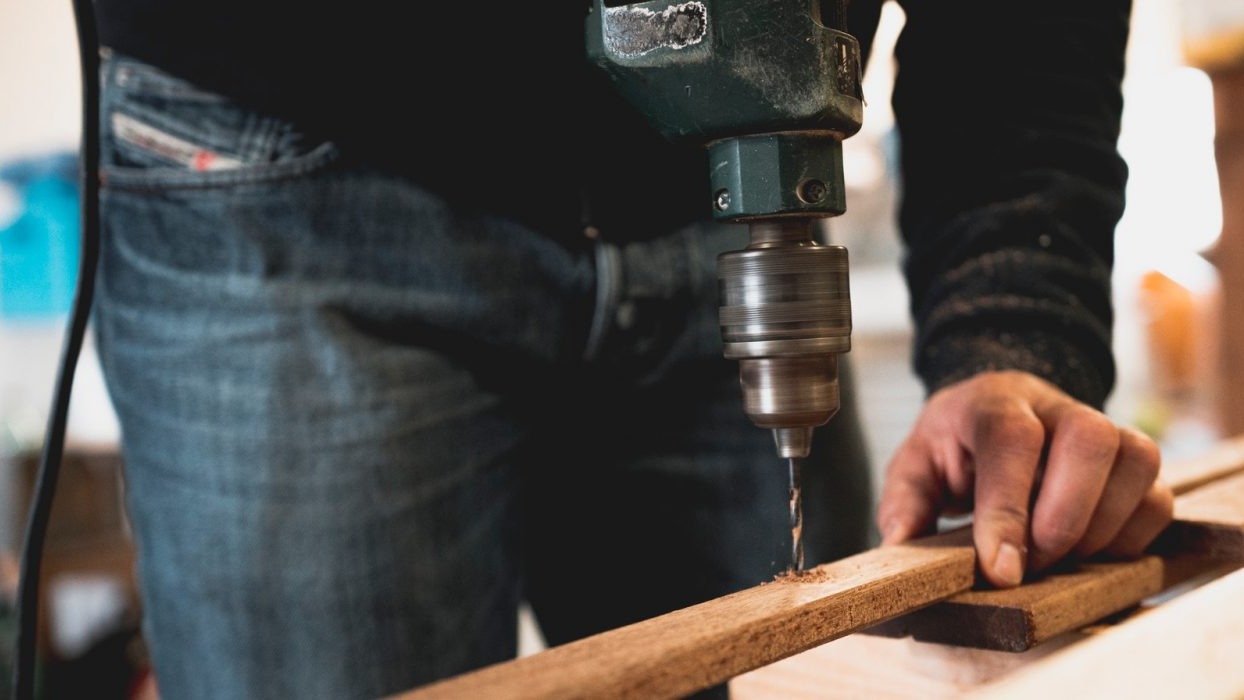 Person drilling into a piece of wood