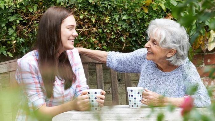 Two people sat in a garden talking