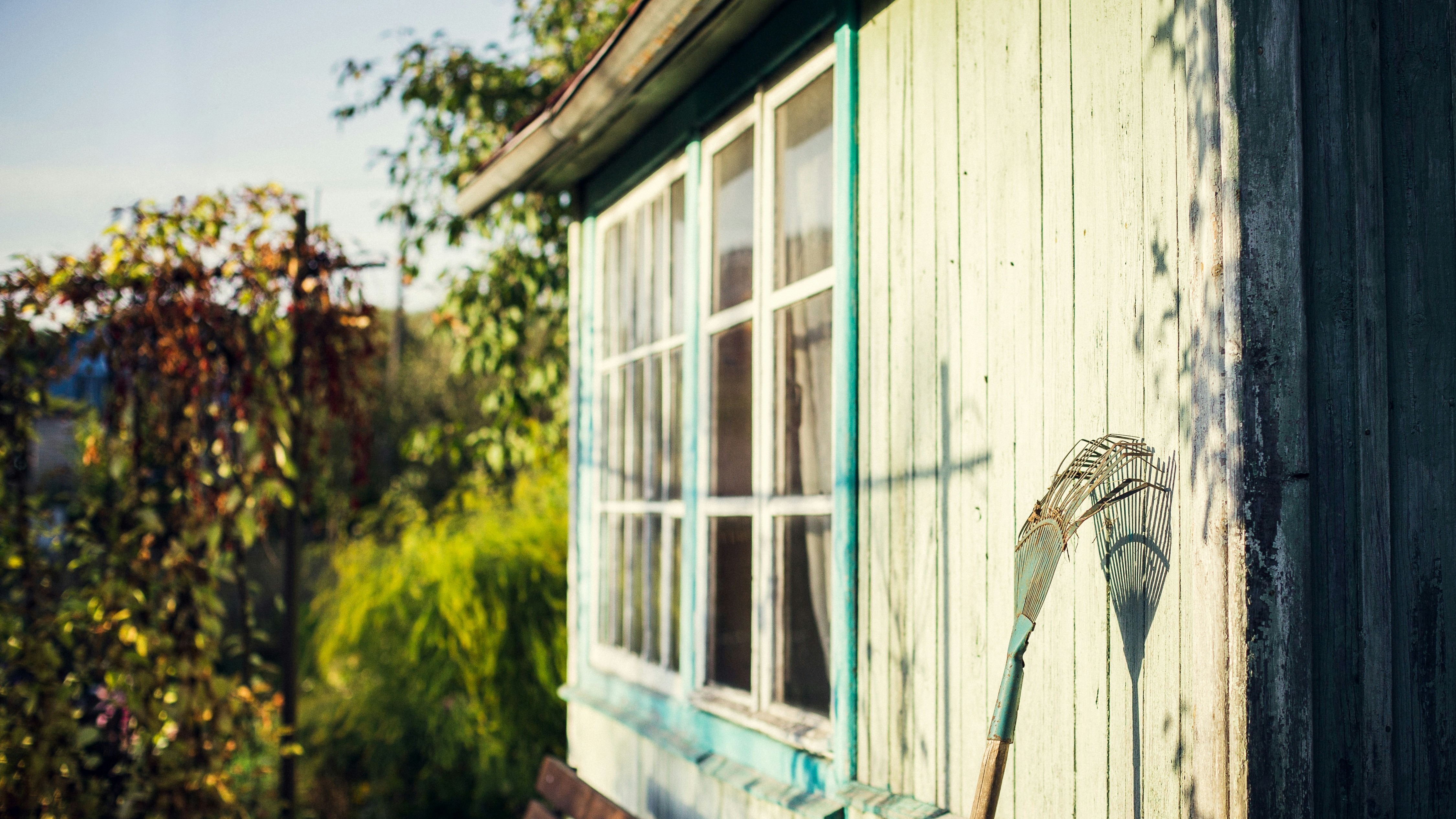 Garden shed with a rake leaning against it