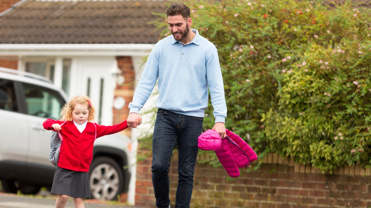 Person and child walking across a street
