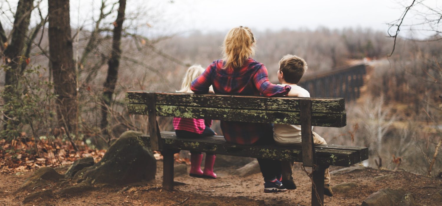 Person sitting on a bench with two children