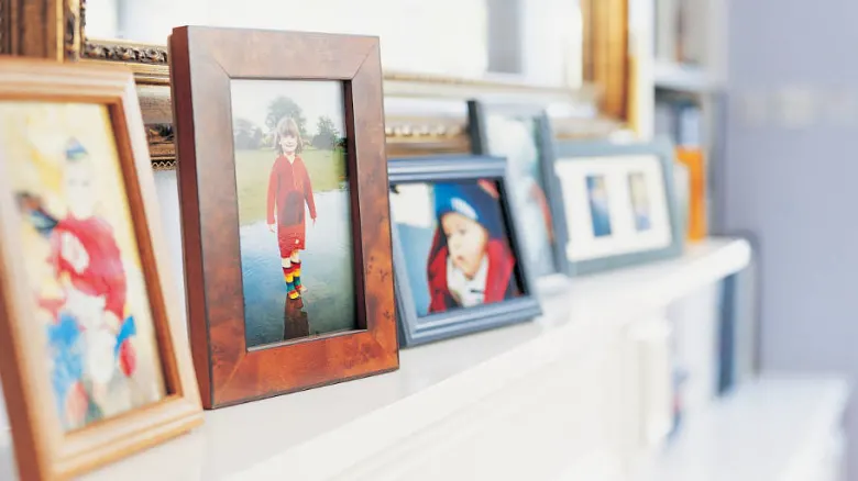 Photo frames on a mantelpiece.