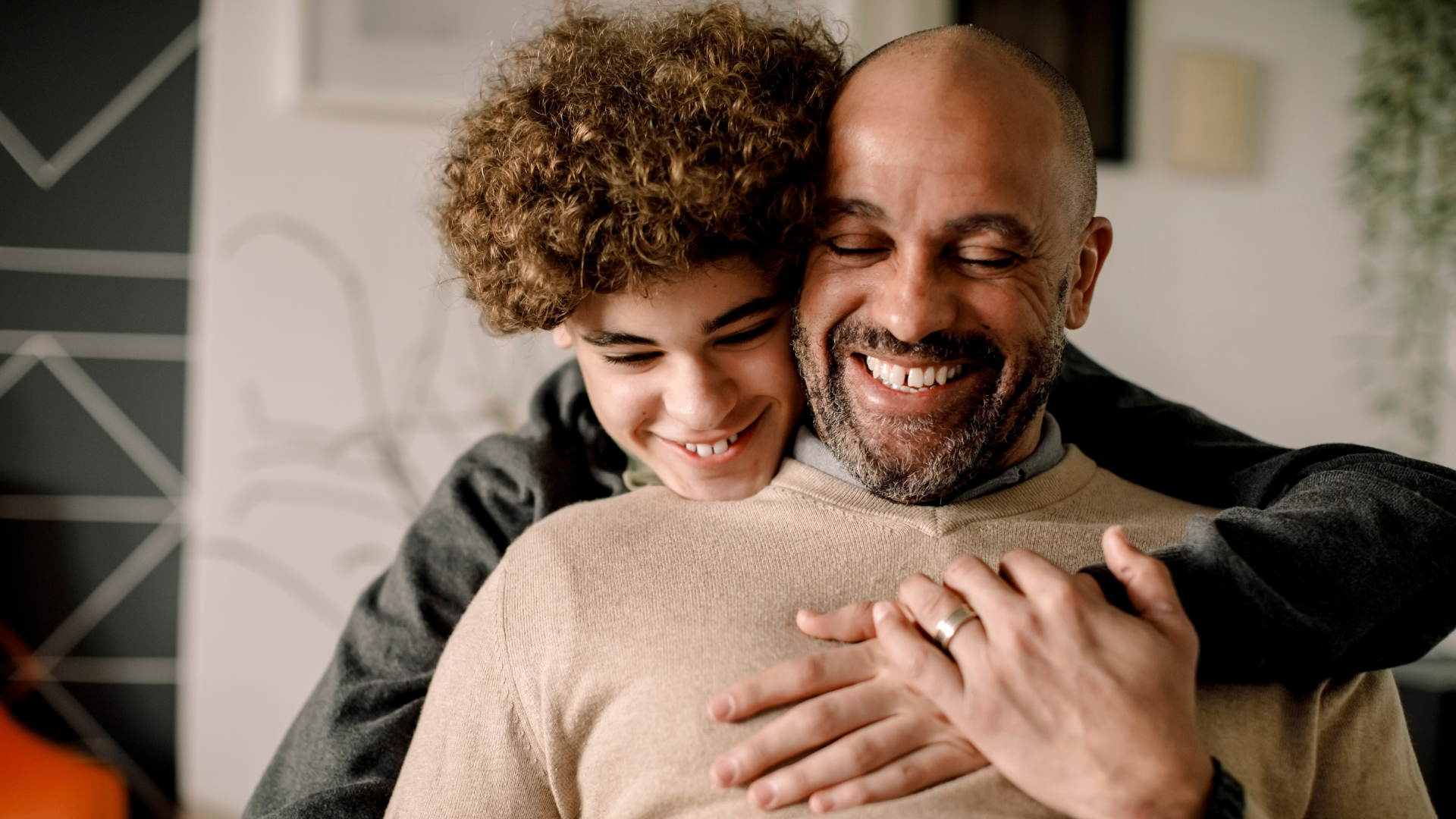 Son hugging father from behind both smiling