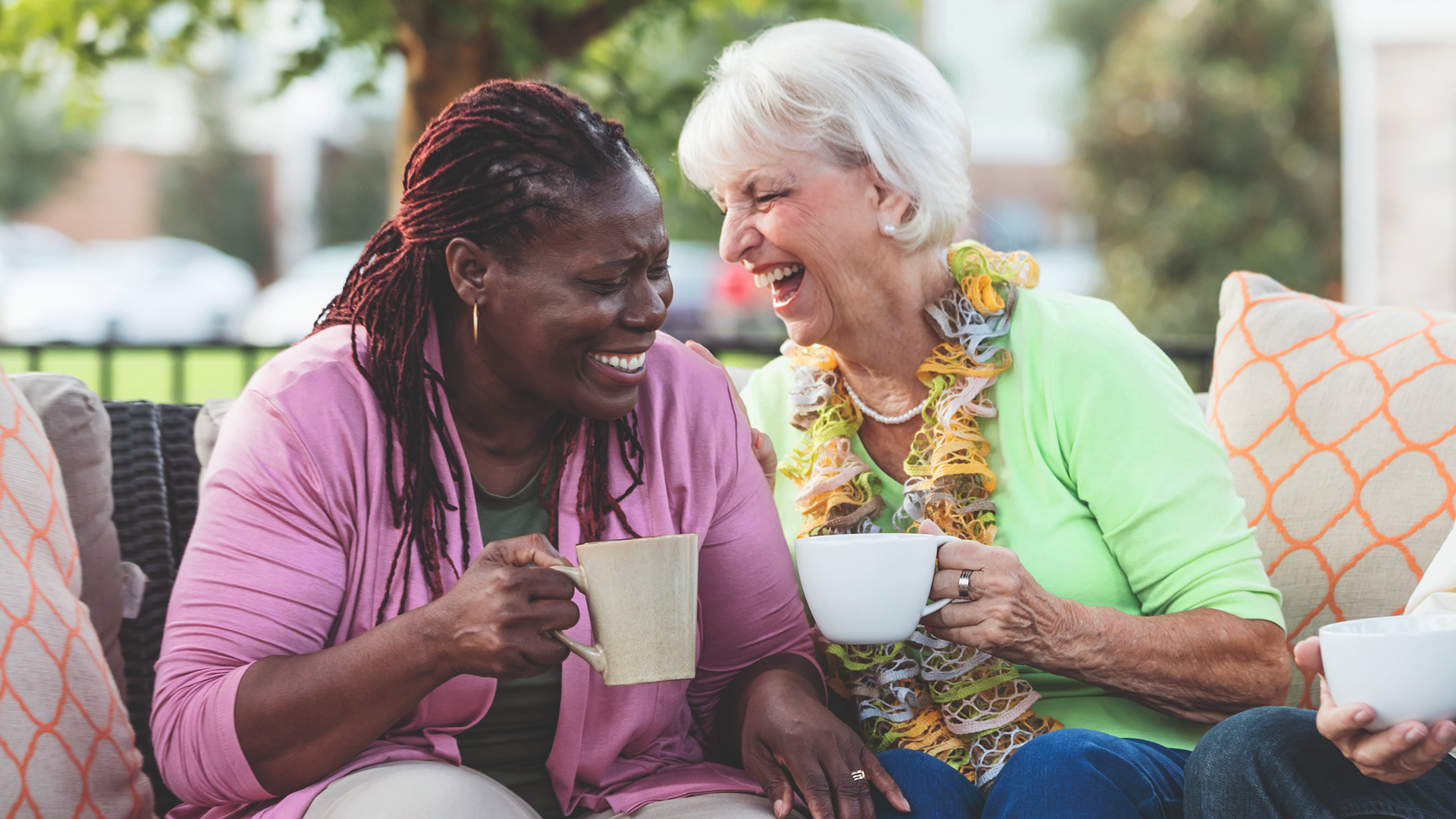 Two women laughing and drinking tea