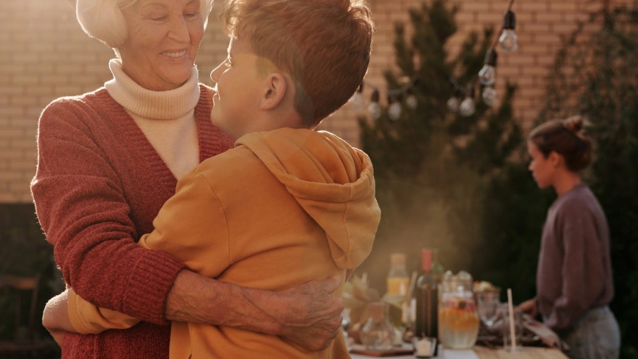 Older person hugging younger person