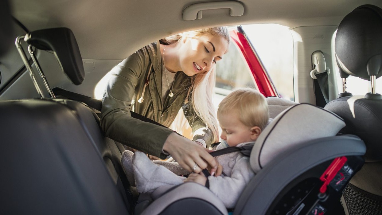 Person strapping baby into a car seat