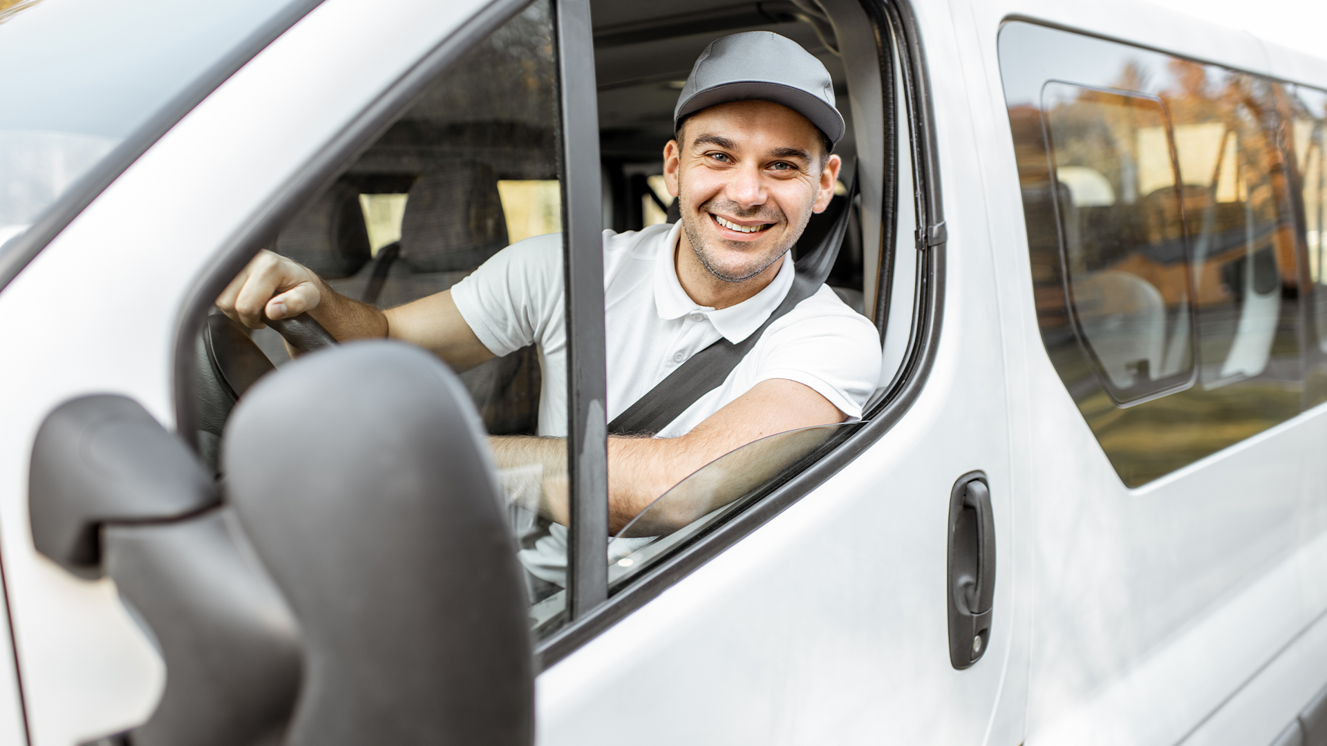 Man sitting in front seat of van smiling