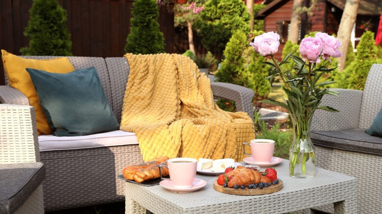 Outdoor furniture and flowers with breakfast on a table