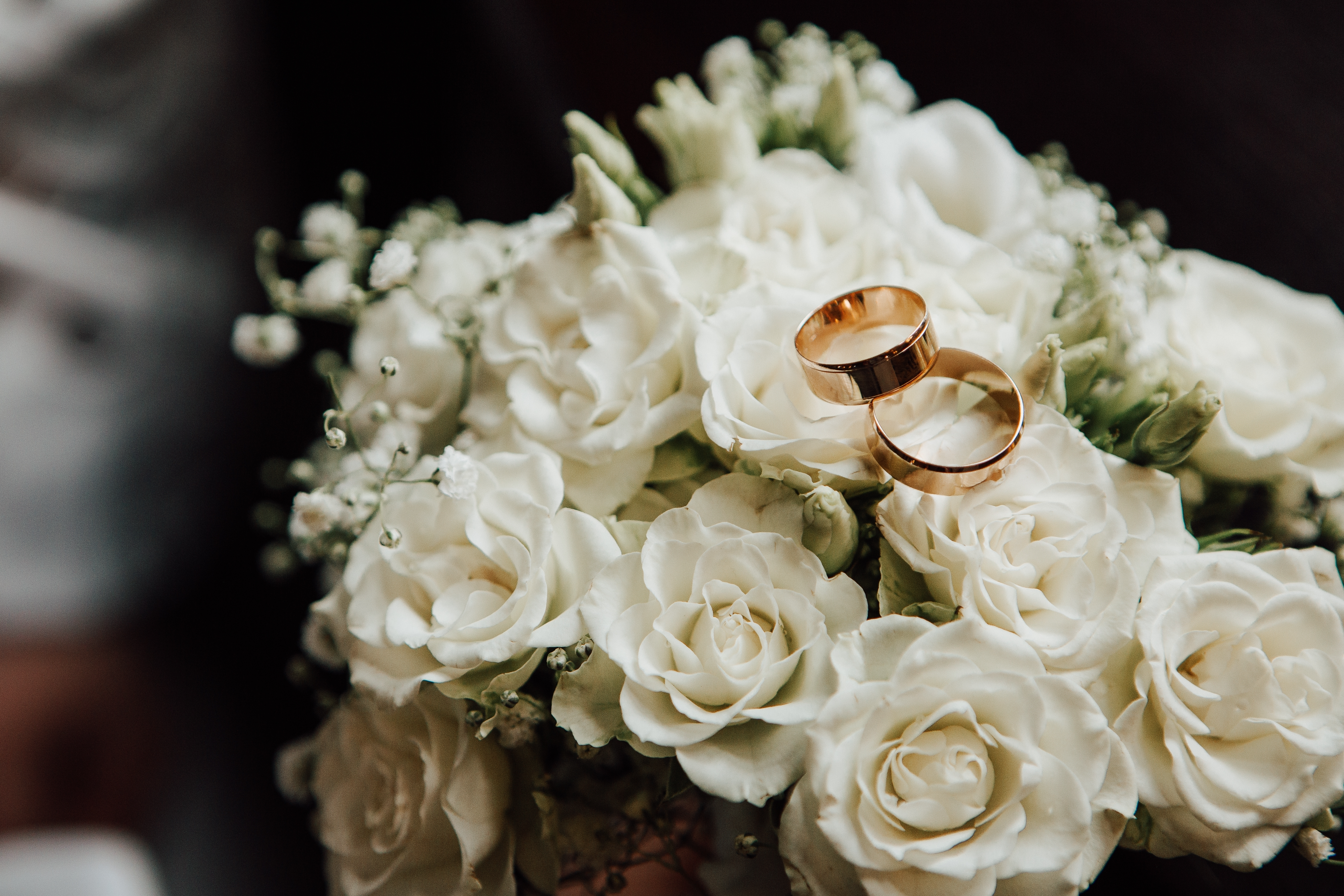 Bouquet of white flowers with two gold wedding rings