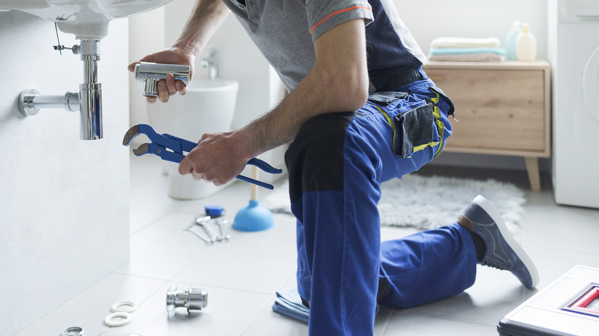 An image of a plumber repairing a sink