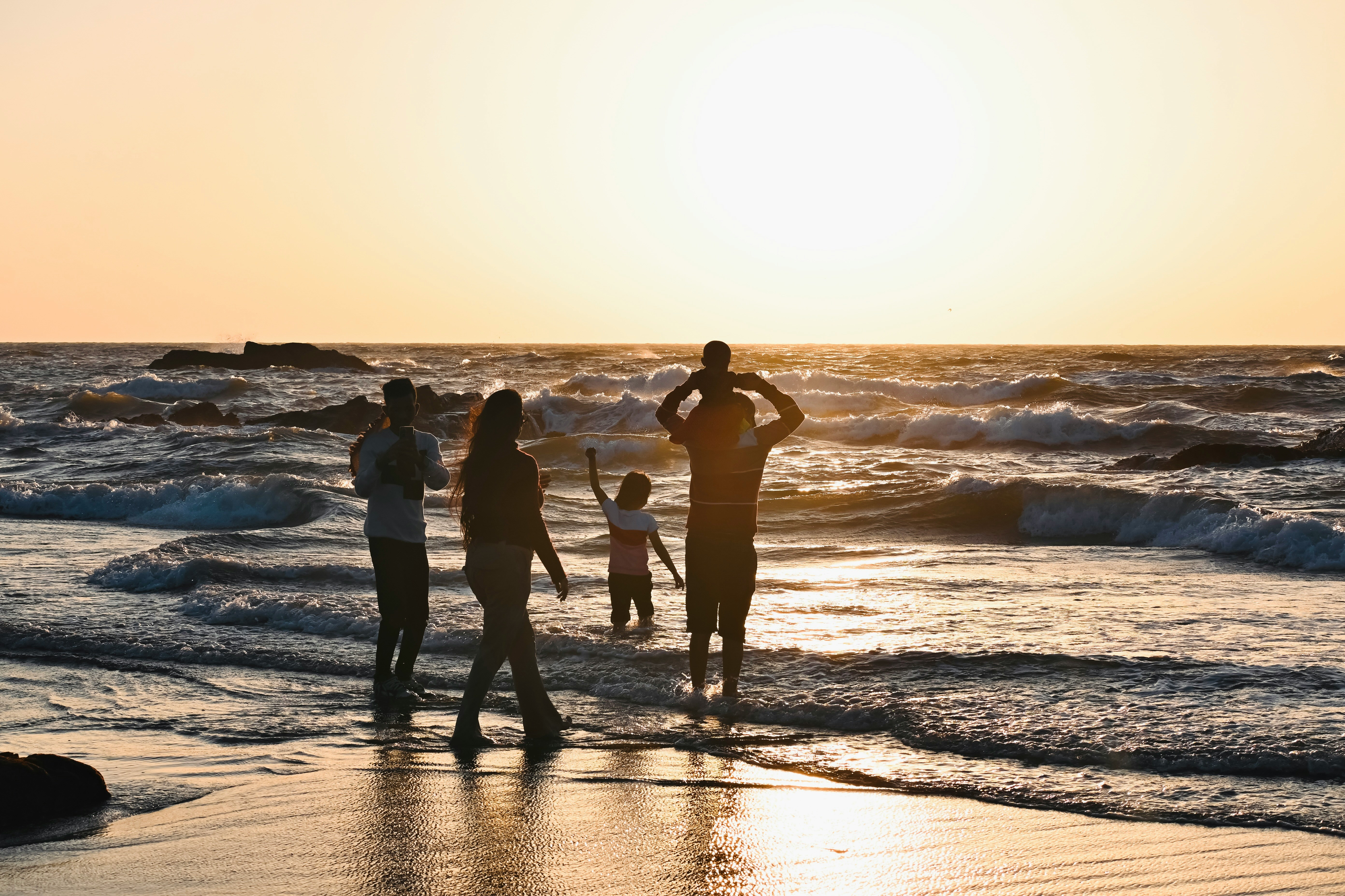 people on a beach at sunset