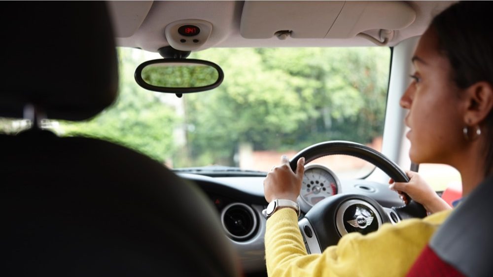 Person driving with both hands on the steering wheel