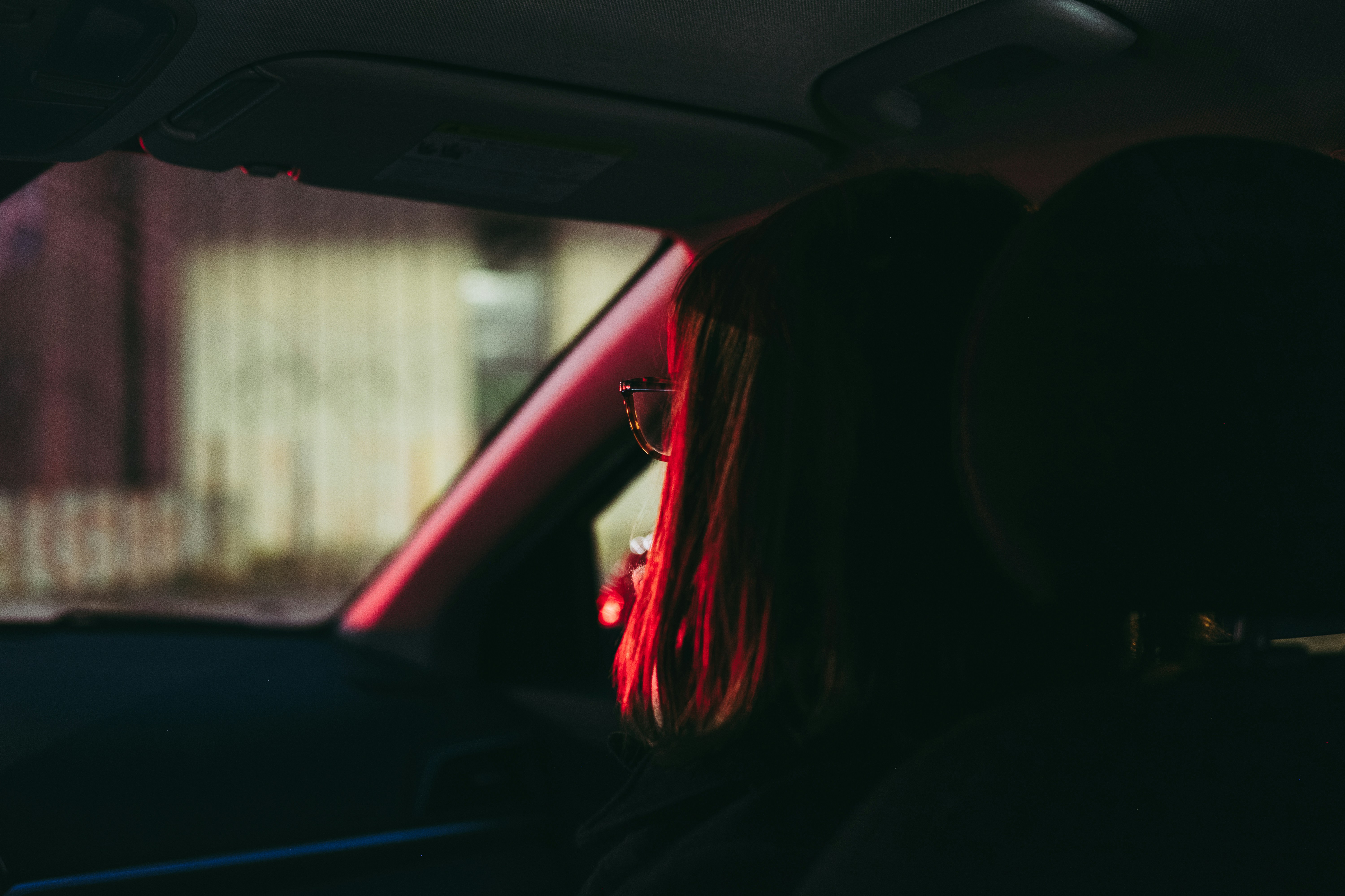 woman with red hair sitting in car