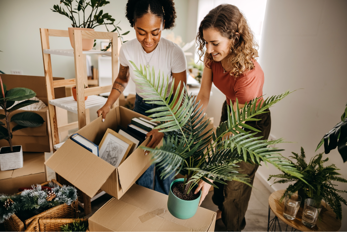 Two woman unpacking some boxes moving house.